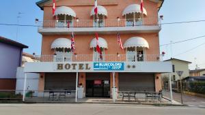 a hotel with tables and chairs in front of a building at BlueColors Hotel ex Hotel Lucy in Campalto