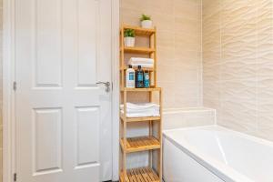 a bathroom with a wooden shelf next to a bath tub at Large 2-Bed House next to Warwick Uni 2x Parking in Canley