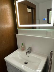 a white sink in a bathroom with a mirror at Hidden Cottage Odenwald in Wald-Michelbach