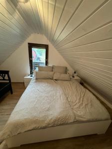 a bedroom with a large bed with a ceiling at Hidden Cottage Odenwald in Wald-Michelbach