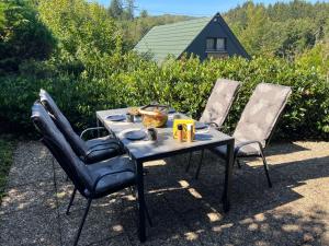 trzy krzesła i stół z jedzeniem w obiekcie Hidden Cottage Odenwald w mieście Wald-Michelbach