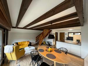 a living room with a wooden table and a kitchen at Hidden Cottage Odenwald in Wald-Michelbach