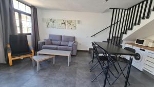 un soggiorno con divano e tavolo di Fresitas Holiday Home a Puerto Rico de Gran Canaria