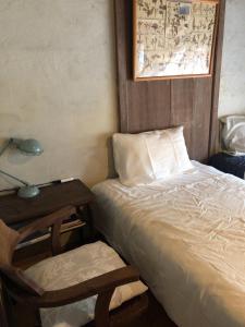 a bedroom with a bed and a lamp and a chair at Travelers House おーさんてぃん青空舎 in Taketomi +37 photos