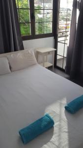 Una cama blanca con dos almohadas azules encima. en Fresitas Holiday Home, en Puerto Rico de Gran Canaria 21 fotos más