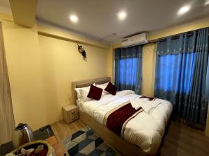 a bedroom with a large bed with blue curtains at Jhigu Chhen in Bhaktapur