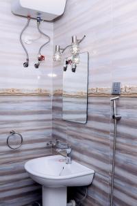 坎帕拉的住宿－Munyonyo Heights Apartments，一间带水槽和镜子的浴室