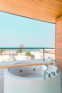 een bad in een kamer met een groot raam bij Côte By The Sea Huahin in Ban Bo Fai