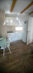 沃迪采的住宿－Mobile home Ivan Vodice，厨房配有绿桌和白色冰箱。