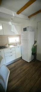 a kitchen with a white refrigerator and a sink at Mobile home Ivan Vodice in Vodice