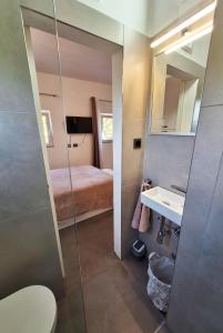 a bathroom with a shower and a sink and a bed at By the Mill in Rogoznica