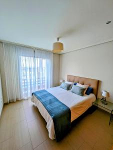 1 dormitorio con cama grande y ventana grande en Flat in La Tejita, Médano, en Granadilla de Abona