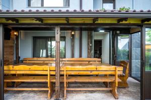 Къща за гости Алекс في كارلوفو: مجموعة من المقاعد الخشبية الجالسة تحت المبنى