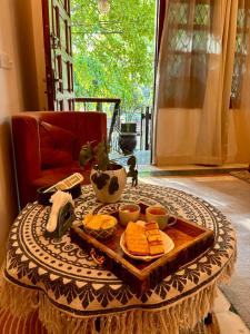 uma mesa com uma bandeja de queijo e bolachas em Atharva's Homestay by Goaround Homes em Nova Deli