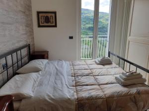 een slaapkamer met 2 bedden en een groot raam bij Il Balcone su Ascoli Piceno in Folignano