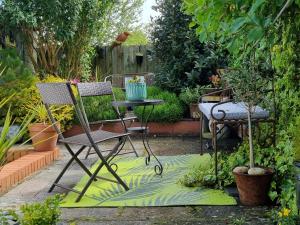 einen Garten mit zwei Stühlen, einem Tisch und Pflanzen in der Unterkunft An Artist's Cottage in Fishguard