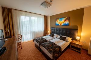 a hotel room with a bed and a television at Hotel Glamour in Kaluža