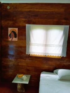 a bedroom with a window with a white curtain at Big Mama's Little House Casa da Mãe Grande in Porto Alegre