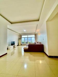 Habitación grande con cama y TV. en Waridi Apartment, en Dar es Salaam