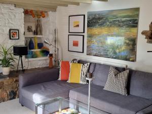 a living room with a gray couch with colorful pillows at An Artist's Cottage in Fishguard