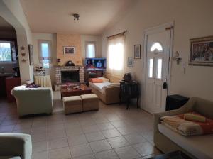 ein Wohnzimmer mit Sofas und einem Kamin in der Unterkunft MARGARET VACATION HOUSE 52 in Kamena Vourla