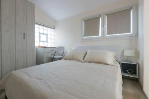 1 dormitorio blanco con 1 cama y 2 ventanas en Mylarakia, en Chios