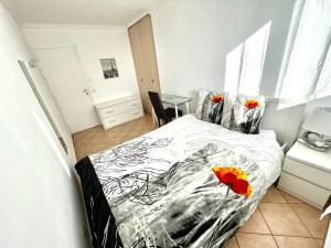 Un dormitorio con una cama con dos flores rojas. en Chambre Privée en colocation dans un appartement Vaulx en Velin Centre en Vaulx-en-Velin