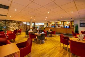 a restaurant with tables and chairs and a bar at Coylumbridge Resort Hotel in Aviemore