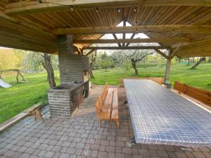 a pavilion with a picnic table and a grill at Forest springs. Family vacation tennis beach sauna in GratiÅ¡kÄ—s