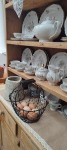 a shelf with eggs in a basket and dishes at The Old House at Belfield in Tralee