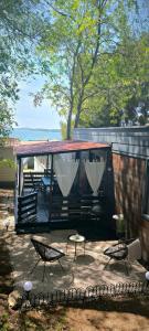 a tiny house with a table and chairs in a yard at Mobile home Ivan Vodice in Vodice