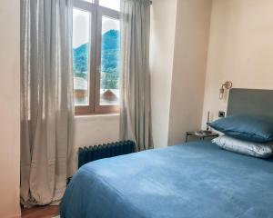 um quarto com uma cama azul e uma janela em The Stone House - 10 Bed Chalet near Morzine em Saint-Jean-dʼAulps