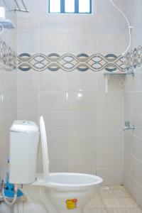 a white bathroom with a toilet and a window at Greenview apartments nanyuki in Nanyuki