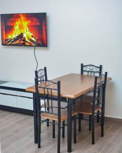 a dining room table with chairs and a fireplace at Greenview apartments nanyuki in Nanyuki