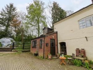 a house with a brick yard next to a building at The Wheelhouse in Church Stretton