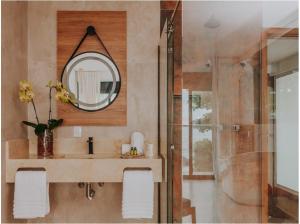 a bathroom with a sink and a mirror at Chez Louise et Louis Pé na Areia in Juquei