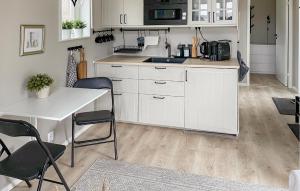 uma cozinha com armários brancos e uma mesa e cadeiras em Amazing Home In Glanshammar With Wifi em Glanshammar