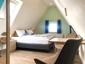 um quarto com uma cama, uma secretária e uma mesa em GRÜNBLAU RELAX Pension & Apartments em Warnemünde