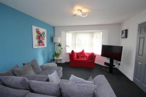 a living room with a couch and a red chair at The Zen Den in Southend-on-Sea