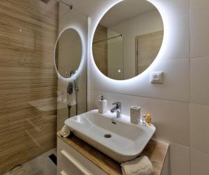 une salle de bain avec un lavabo et un miroir dans l'établissement Apartman SAN, à Mostar 14 autres photos