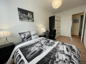 a black and white bedroom with a bed and a desk at Chambre Privée en colocation dans un appartement Vaulx en Velin Centre in Vaulx-en-Velin