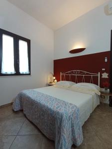 a bedroom with a large bed and two windows at Tenuta I Quattro Venti in Otranto