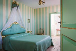una camera con letto blu a baldacchino di AGRITURISMO CASTELLO BECCARIA a Pieve del Cairo