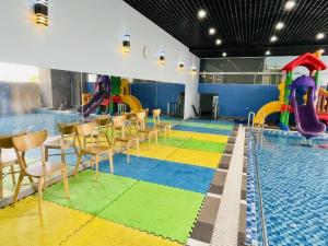 uma piscina com escorrega e mesas e cadeiras em Căn Hộ OASKY,3 Phòng View Đẹp Nhìn Ra Biển,Núi Và Hồ Bàu Sen em Vung Tau