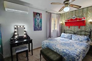 1 dormitorio con cama, espejo y piano en La Casona de Karkabul, en Carcabuey