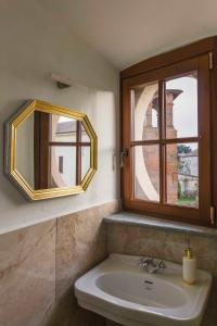 bagno con lavandino e specchio di AGRITURISMO CASTELLO BECCARIA a Pieve del Cairo