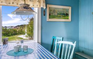 uma sala de jantar azul com uma mesa e uma janela em Cozy Home In Norddyry With Kitchen em Sætra