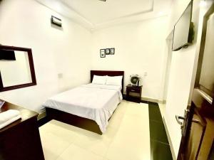 sypialnia z łóżkiem i telewizorem w obiekcie OYO 1196 Le Vu Hotel w mieście Da Lat