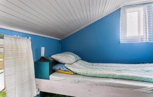 a bed in a blue room with a window at Cozy Home In Norddyry With Kitchen in Sætra