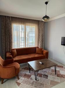 a living room with a brown couch and a coffee table at palmiye butik otel in Mezitli